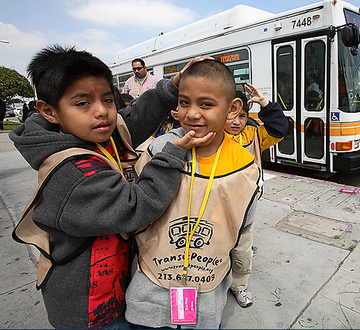 One child helping another to smile seems like one of the easier challenges teachers could face on a "free transit field trip."  Photo: ##http://www.transitpeople.org/photo.shtml##Tim Adams/Transit People##