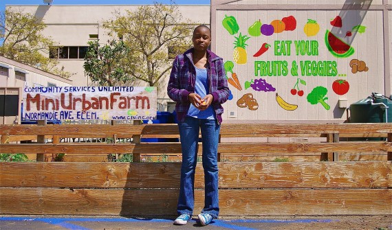 Nina, an intern with Community Services Unlimited, stands in front of the mini-urban farm at Normandie Elementary. Sahra Sulaiman/Streetsblog L.A.