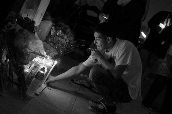Jose Vasquez leaves a candle at the ghost bike memorial for Andy Garcia, killed in a vicious hit-and-run last year.  Sahra Sulaiman/LA Streetsblog