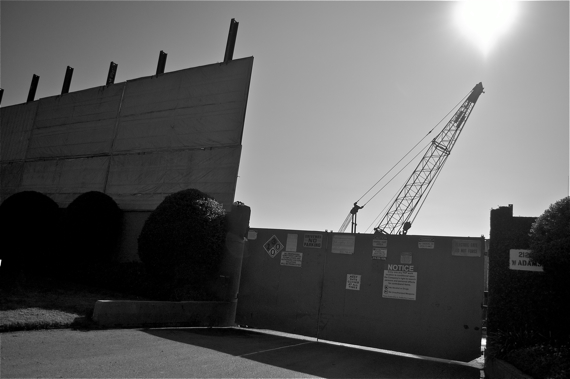 A crane peeks out from behind a makeshift wall recently put up by Freeport-McMoRan at the Murphy Drilling Site. Sahra Sulaiman/LA Streetsblog