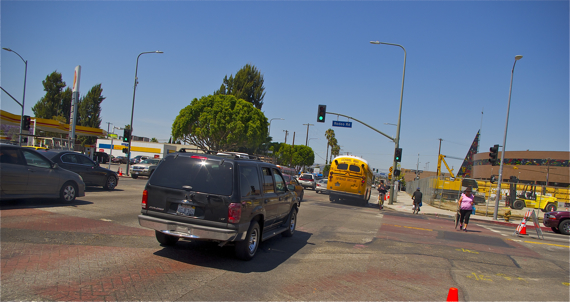 Cyclists battle for space near Crenshaw and Exposition. One takes his chances in the street while the other opts for the safety of the sidewalk. Sahra Sulaiman/LA Streetsblog