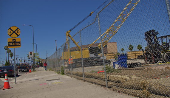 A boy walks past the staging area for the Crenshaw Line at Crenshaw and Exposition. Recently erected sound barriers can be seen along Exposition. Sahra Sulaiman/LA Streetsblog