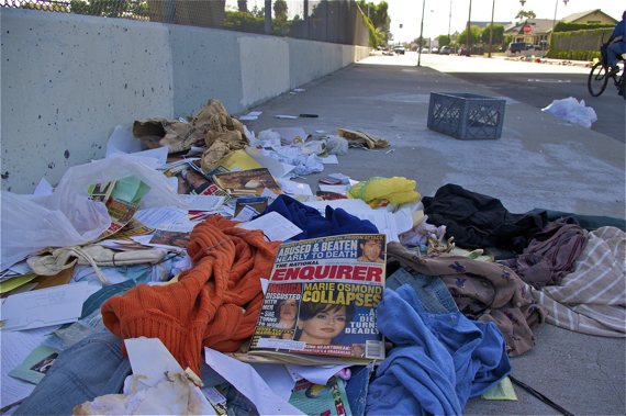Piles of random clothing and issues of the National Enquirer from the year 2000 (at the overpass at 52nd and Broadway) Sahra Sulaiman/Streetsblog LA