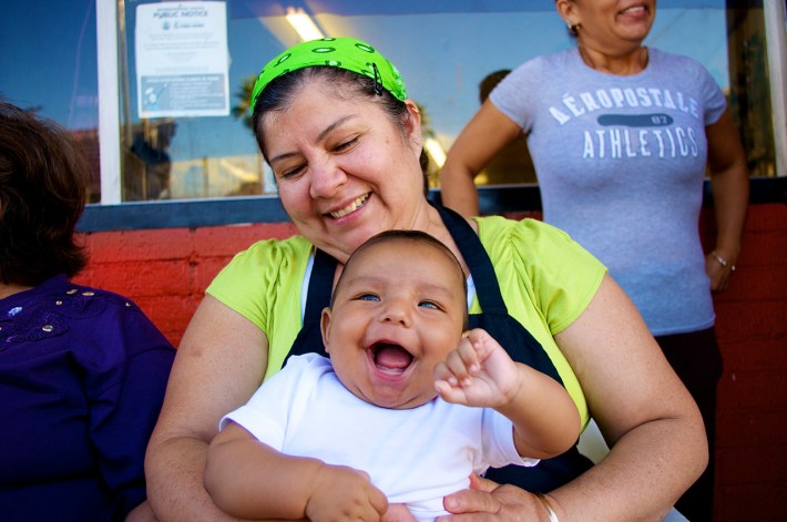 Lupita Barajas sits in front of her restaurant, Yeya's (across the street from Mariachi Plaza), with her grandson, Julian. Sahra Sulaiman/Streetsblog LA