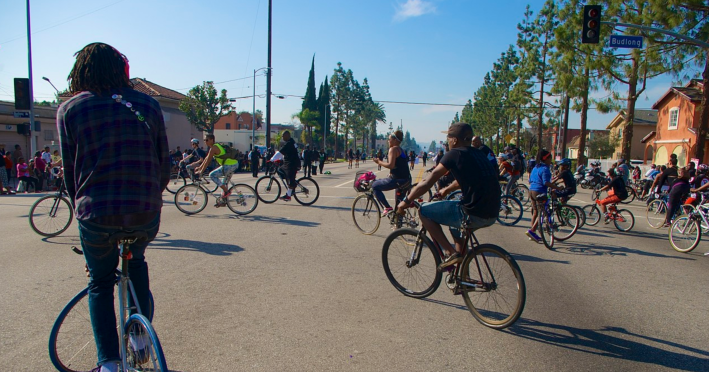 A rider performs a track stand (at left) while others loop around and head back down the boulevard. Sahra Sulaiman/Streetsblog L.A.