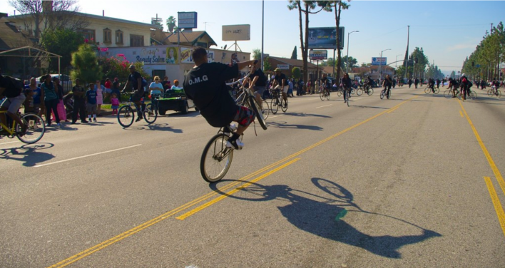 A rider pops a wheelie as the others ride in a circle. Sahra Sulaiman/Streetsblog L.A.