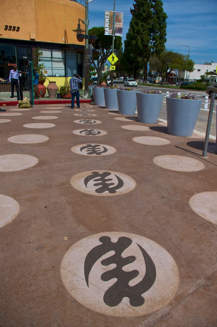 Some of the Adinkra symbols community members have been painting in the polka dots on the People St Plaza in Leimert Park. Sahra Sulaiman/Streetsblog L.A.