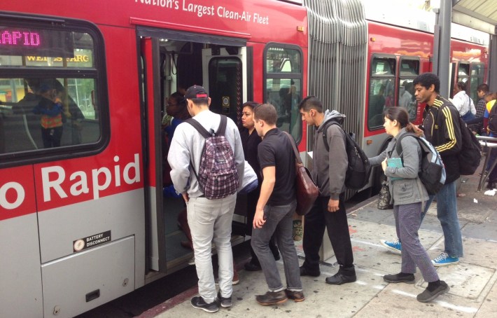 Riders getting on the back door of the Metro 720 bus