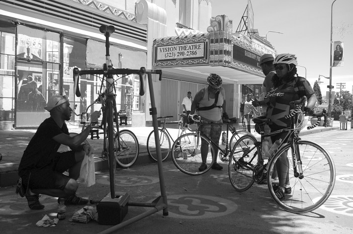 Erik Charlot works on a bike while chatting with some of the lovely ladies of Major Motion. Sahra Sulaiman/Streetsblog L.A.