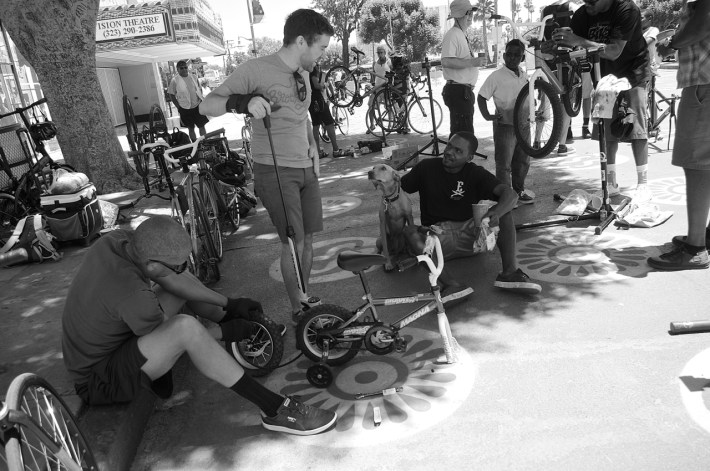 Michael Glasco, Michael MacDonald, dog Tobey, and Malik Mack make sure a tiny bike is in working order. Sahra Sulaiman/Streetsblog L.A.