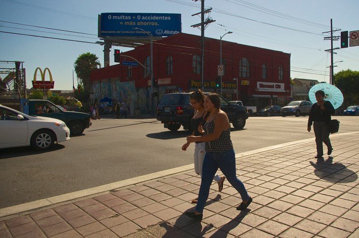Pedestrians cross Soto along Cesar Chavez. Across the street, would-be passengers gather at the bus stop. Sahra Sulaiman/Streetsblog L.A.