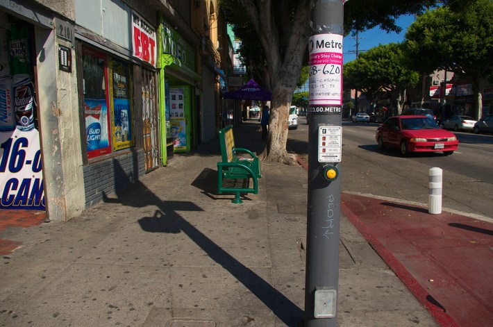 The original bus stop at St. Louis and the notice of the change. The bollard at right blocks bus access. Sahra Sulaiman/Streetsblog L.A.