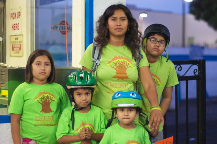 Maria Almeida stands with her children after the press conference. Her bike is outfitted with a saddle on the crossbar where her youngest child sits. Sahra Sulaiman/Streetsblog L.A.