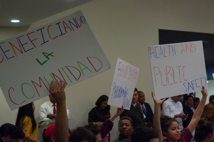 Youth hold up signs matching talking points on the Reef's power point presentation. Sahra Sulaiman/Streetsblog L.A.