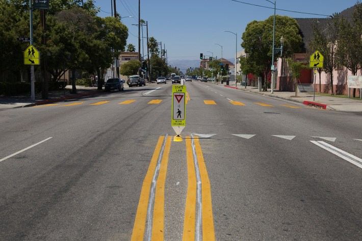 Crosswalks in South LA are being upgraded along high priority corridors in pursuit of Vision Zero. The upgrades include reminders that stopping for pedestrians is the law. Sahra Sulaiman/Streetsblog L.A.