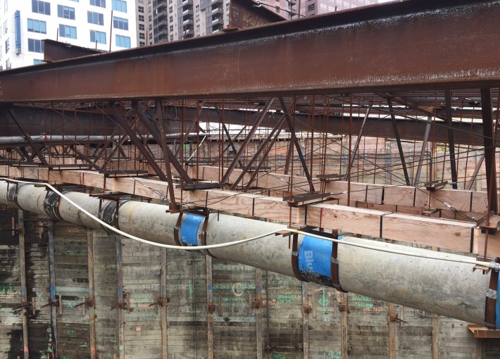 A major difficulty for Regional Connector construction has been interacting with utilities. In this photo, a near-surface level concrete storm drain is suspended high above the construction site