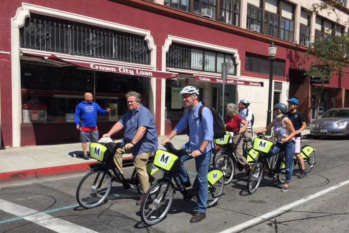 A pedestrian asks the bike-share group about Pasadena's new system