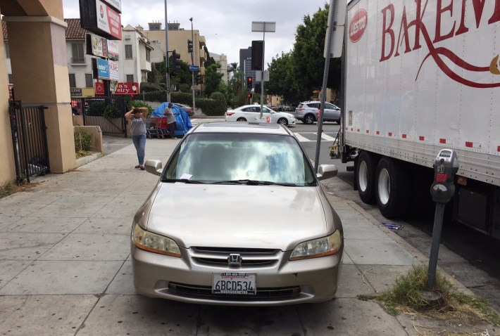 Car parked on Koreatown sidewalk this afternoon. Note the citation on the windshield.