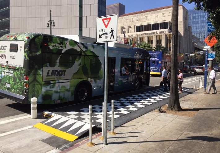 Riders board an electric DASH bus via the new platform