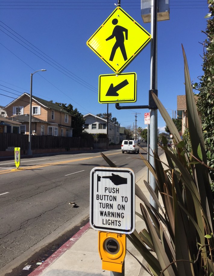 Pedestrians push the button to activate the flashing signage