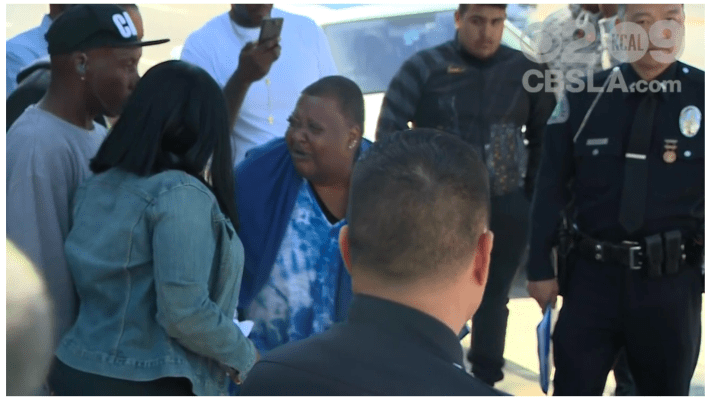 A distraught Beverly Owens pushes supporters aside in her grief at a press conference regarding the killing of her son by a hit-and-run driver. [Screenshot from CBS broadcast]