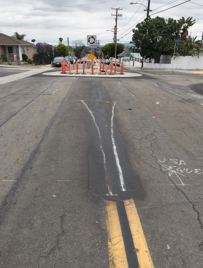 Additional striping underway to direct drivers around the traffic circles - photo at Budlong and 127th