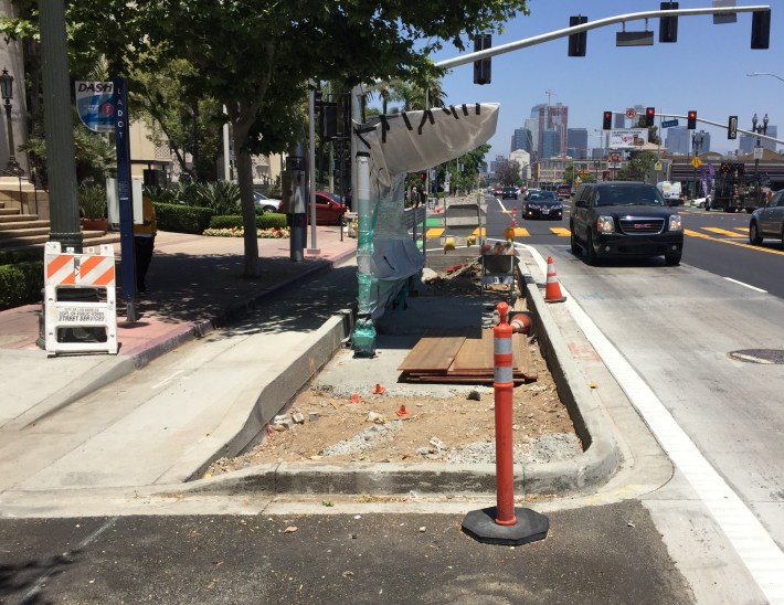 New floating bus island under construction on Figueroa. The protected bike lane goes between the island and the curb.