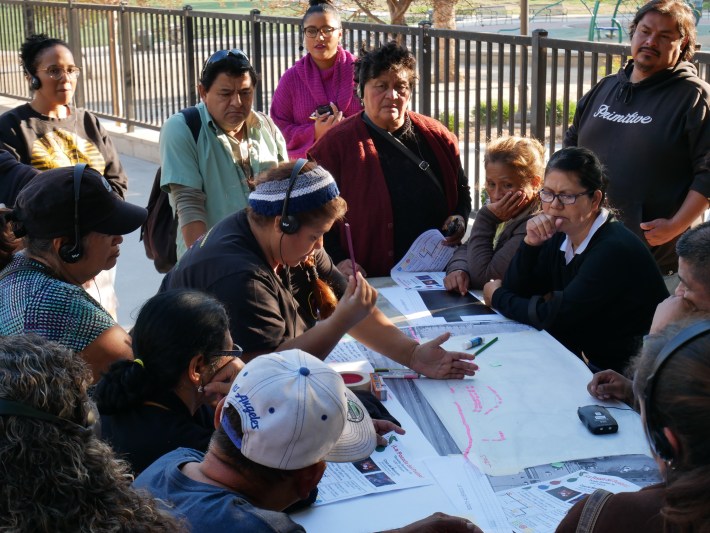 Street vendors in MacArthur Park discuss alternative configurations for the pilot vending district at the Metro station there. Photo: Monique López