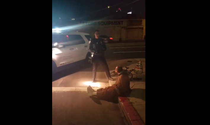 Monday, February 11, a man was detained and handcuffed by USC's Department of Public Safety for riding on Washington Boulevard without a bike light. According to the officer who conducted the stop, the man requested to be allowed to sit down because he has a bad back. Screen grab from Facebook live video streamed by Estuardo David Mazariegos.