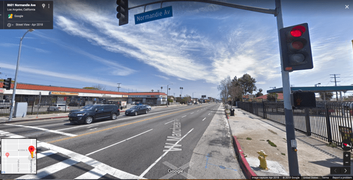 The gutter lane on Manchester and Normandie. On the day he was hit, Woon would have seen parked cars just up ahead near the trees. The narrow strip of asphalt between the lane markers and the cement is often the only safe space open to cyclists between fast-moving traffic and parked cars. Source: Google maps