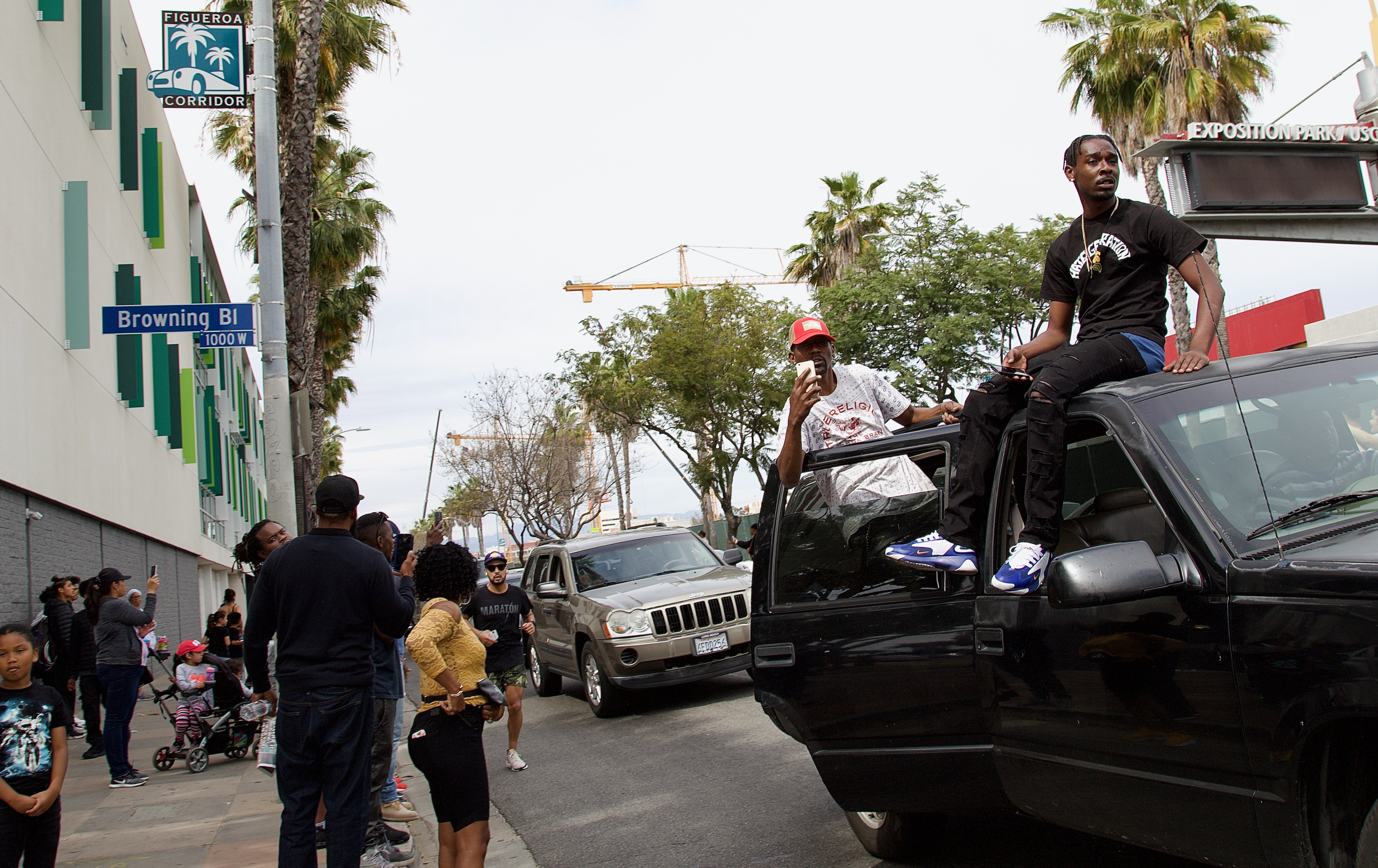 Mourners along Vermont Avenue, near King Blvd. The marathon runner is visible coming up alongside the procession. Sahra Sulaiman/Streetsblog L.A.