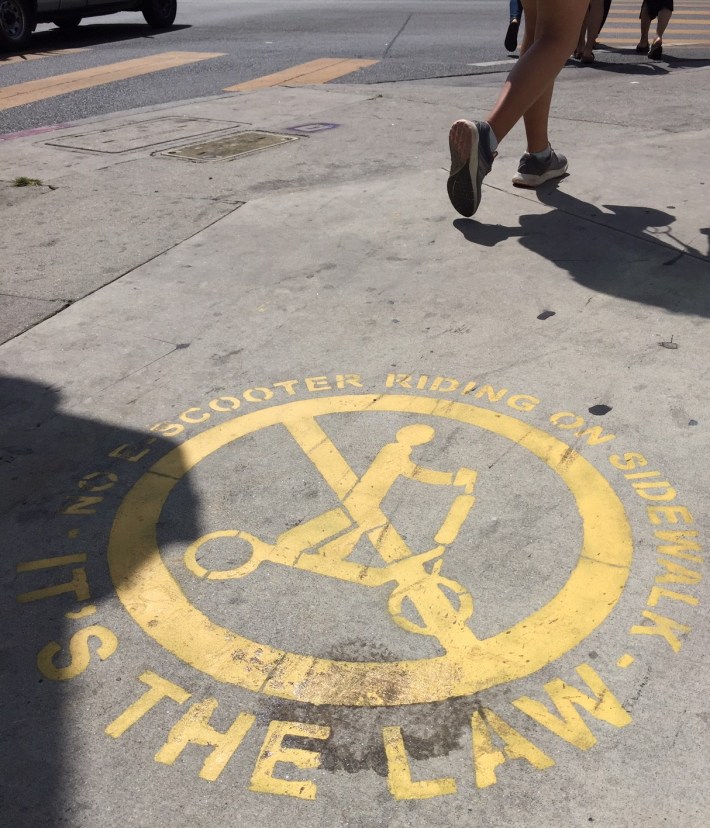 "No scooter riding on sidewalk" stencil