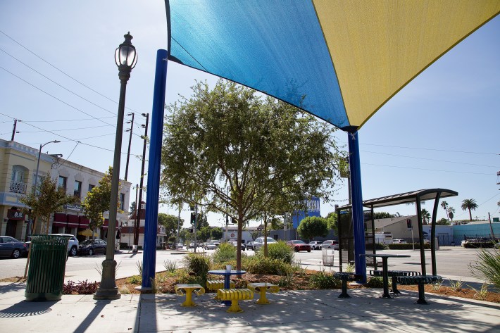 A canopy shades picnic tables for kids and adults and offers those waiting for the bus some relief when the bus shelter canopy comes up short. Sahra Sulaiman/Streetsblog L.A.