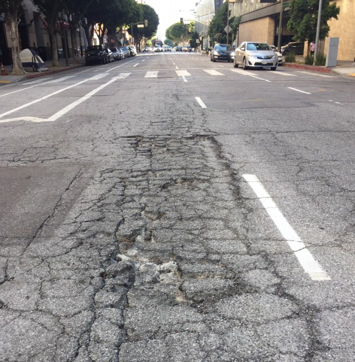 Downtown's Olive Street needs repaving, but at the same time the city could add the planned bus-only lane, and convert the buffered bike lane to protected. Photo by Joe Linton/Streetsblog L.A.