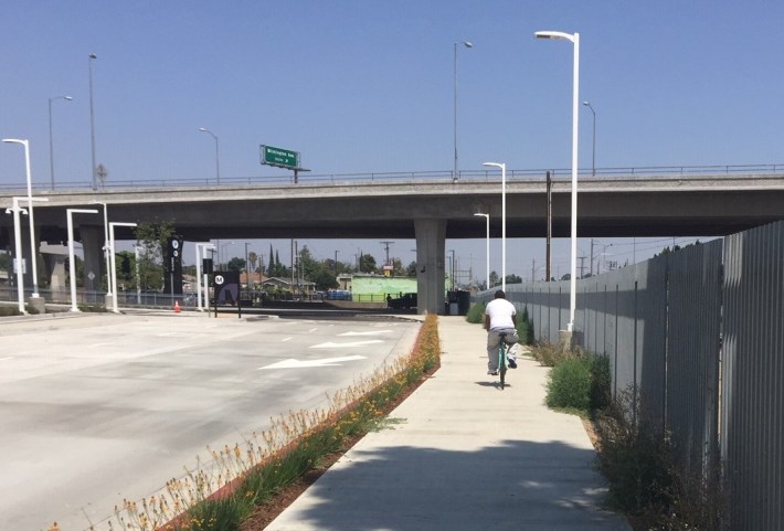 Cyclist riding on sidewalk where Metro had planned a cycle track