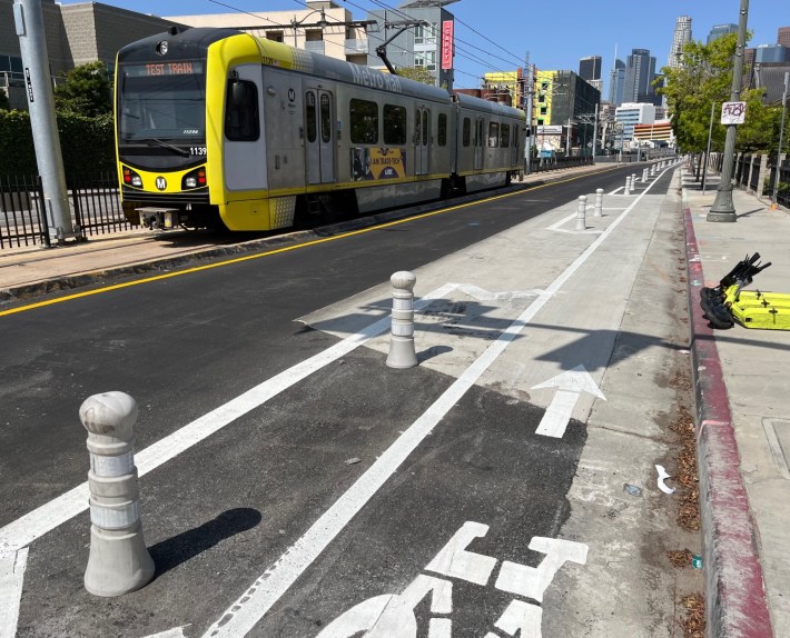 Regional Connector test train running in the middle of First Street - new protected bike lane on the right